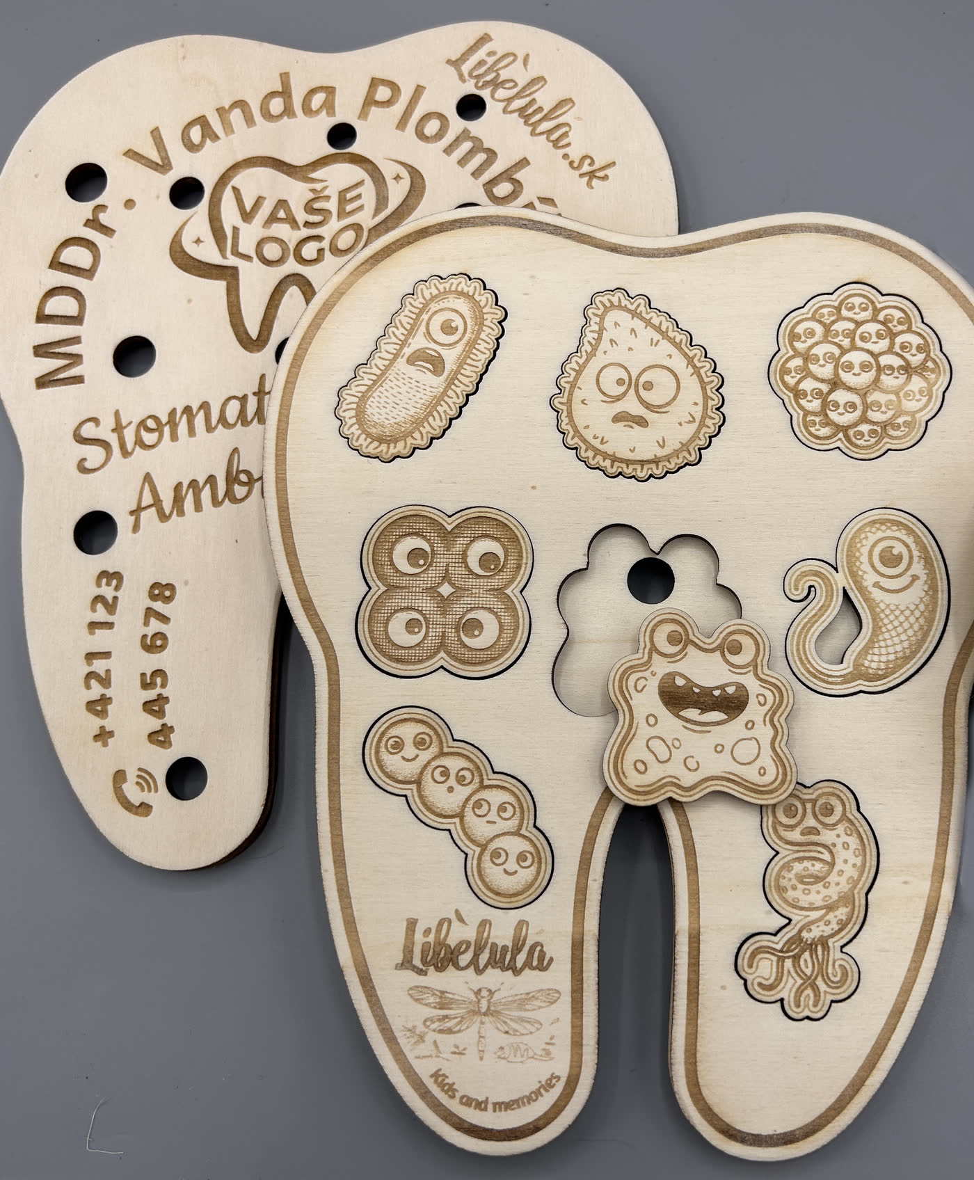 Einlegepuzzle aus Holz in Zahnform, graviert mit Name, Adresse und Telefonnummer einer Zahnarztpraxis