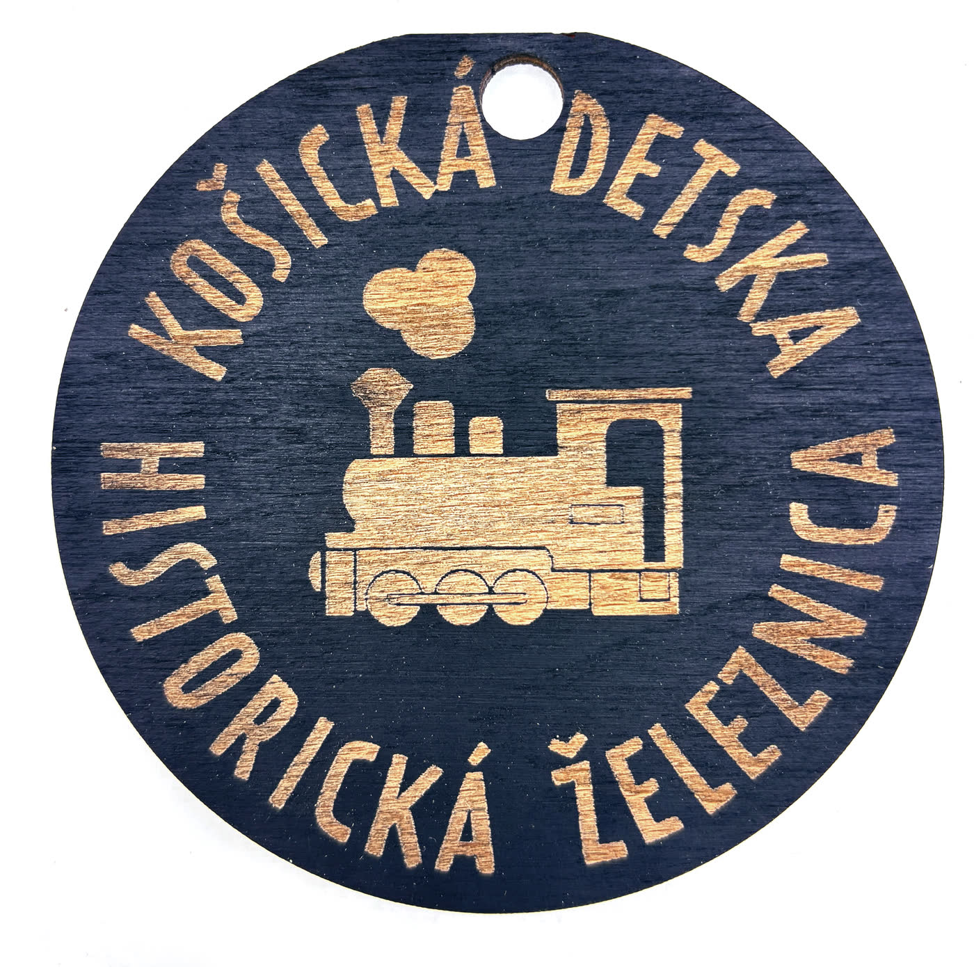 Médaille ronde en bois gravée d’une locomotive à vapeur et du nom du chemin de fer historique des enfants de Košice