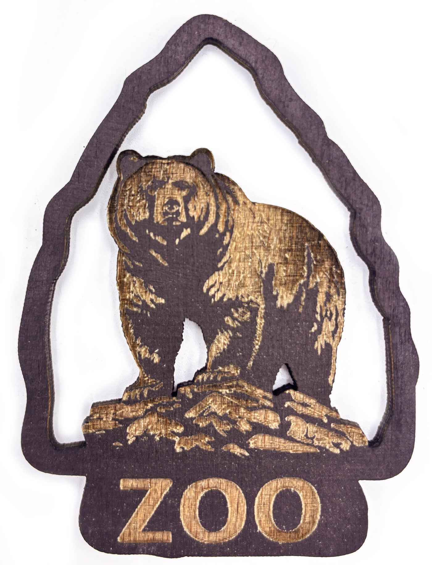 Médaillon souvenir en bois avec un ours gravé en relief et le mot ZOO en dessous